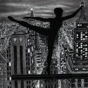 a beautiful ballerina balanced on one toe high above new york city at night silhouette fine art charcoal drawing